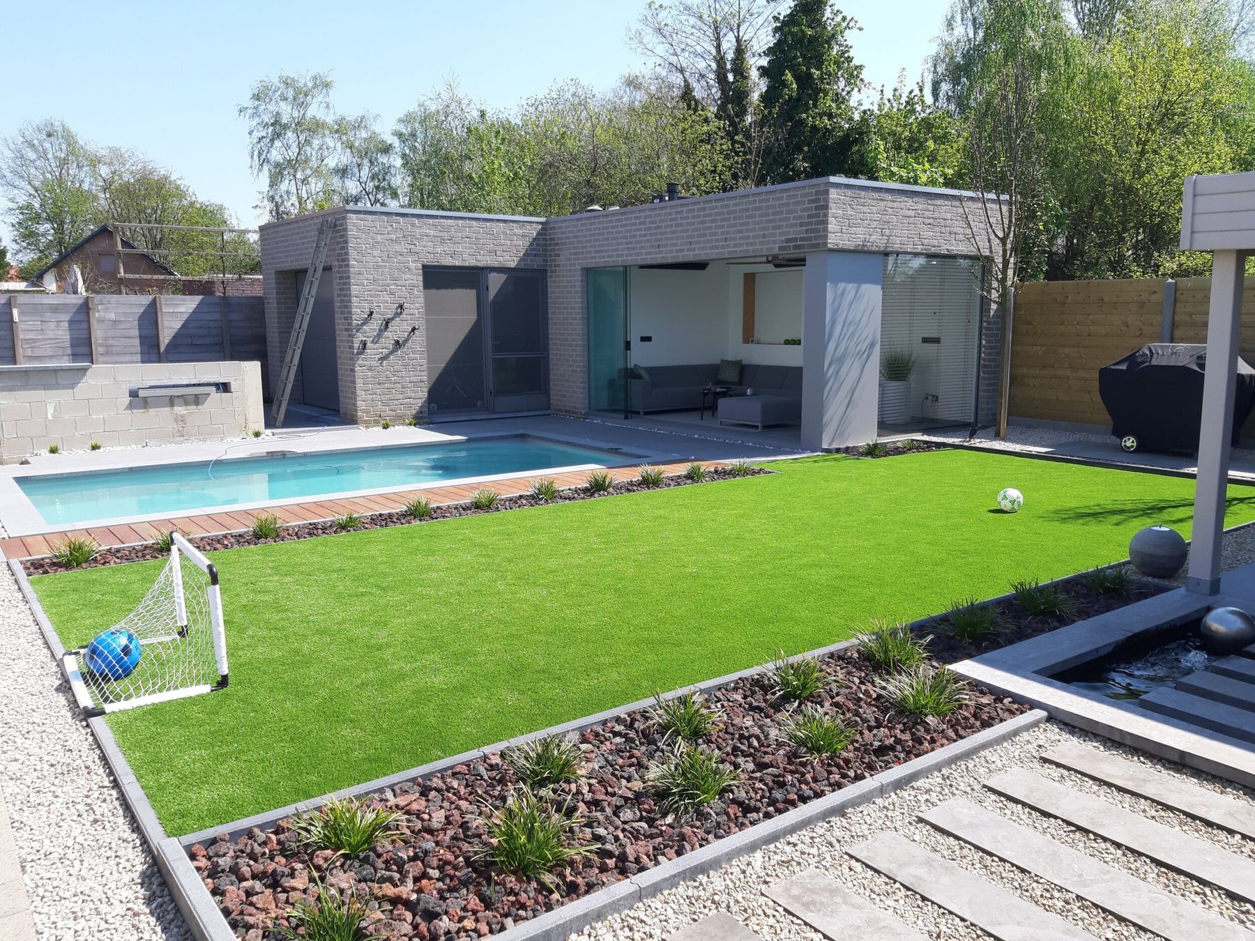 Moderner Garten mit Pool, Fußballtor und großer Kunstrasenfläche