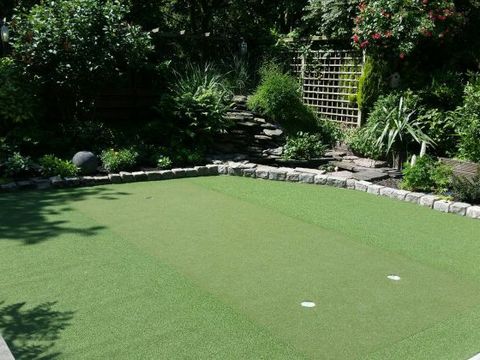 Minigolfbahn aus kurzflorigem Kunstrasen mit Natursteineinfassung