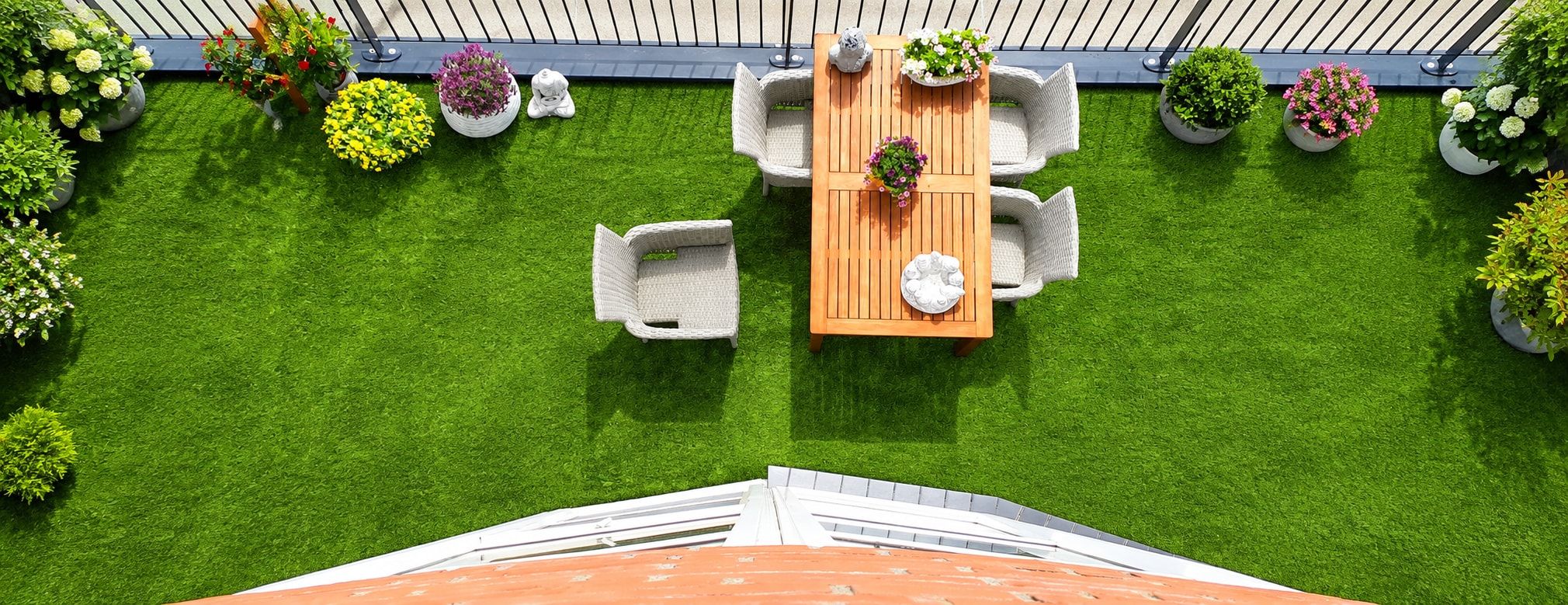 Dachterrasse von oben mit Kunstrasen, Sitzgruppe und Pflanzkübeln